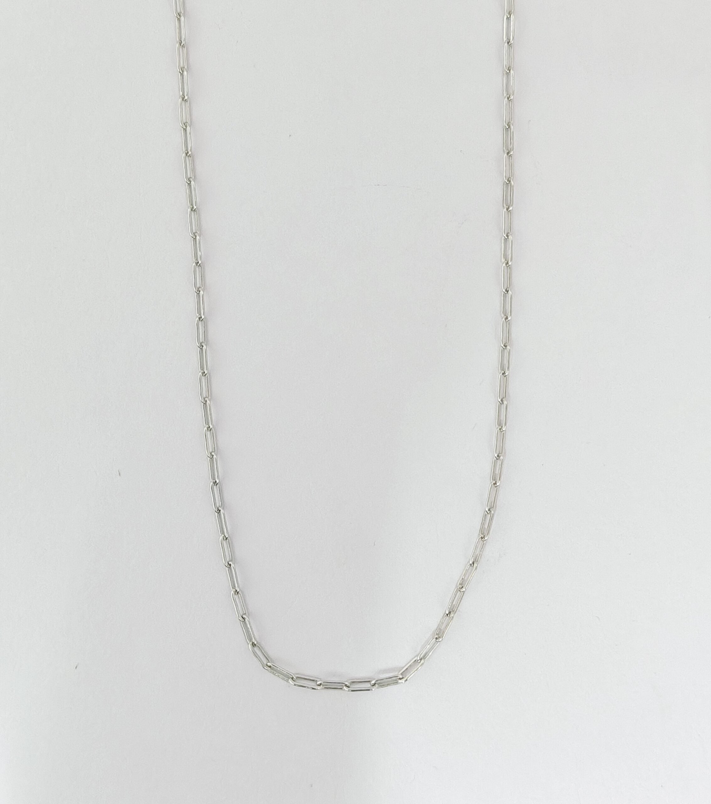 Silver chain necklace on a light gray background